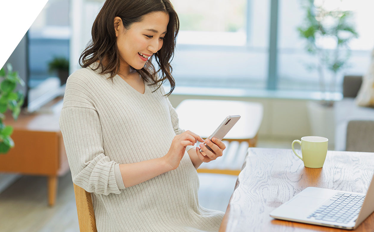 写真：妊婦さんが携帯を触る様子